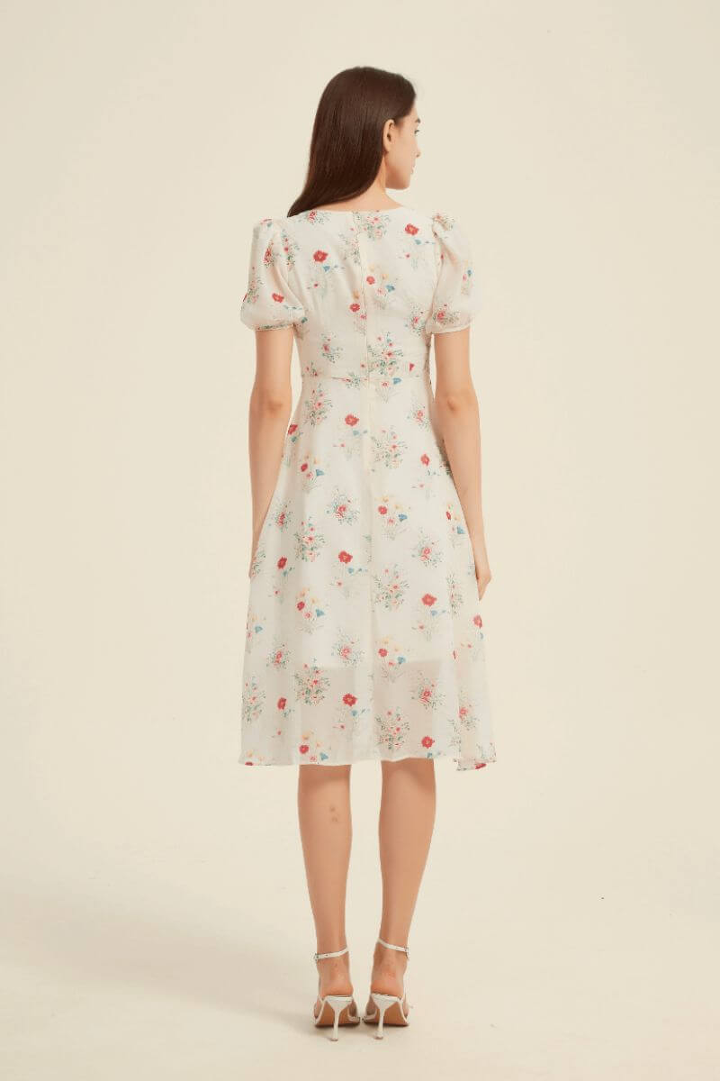 Back view of a cream floral midi dress showing fitted waist and flowy skirt — elegant puff-sleeve design perfect for countryside or vacation days.