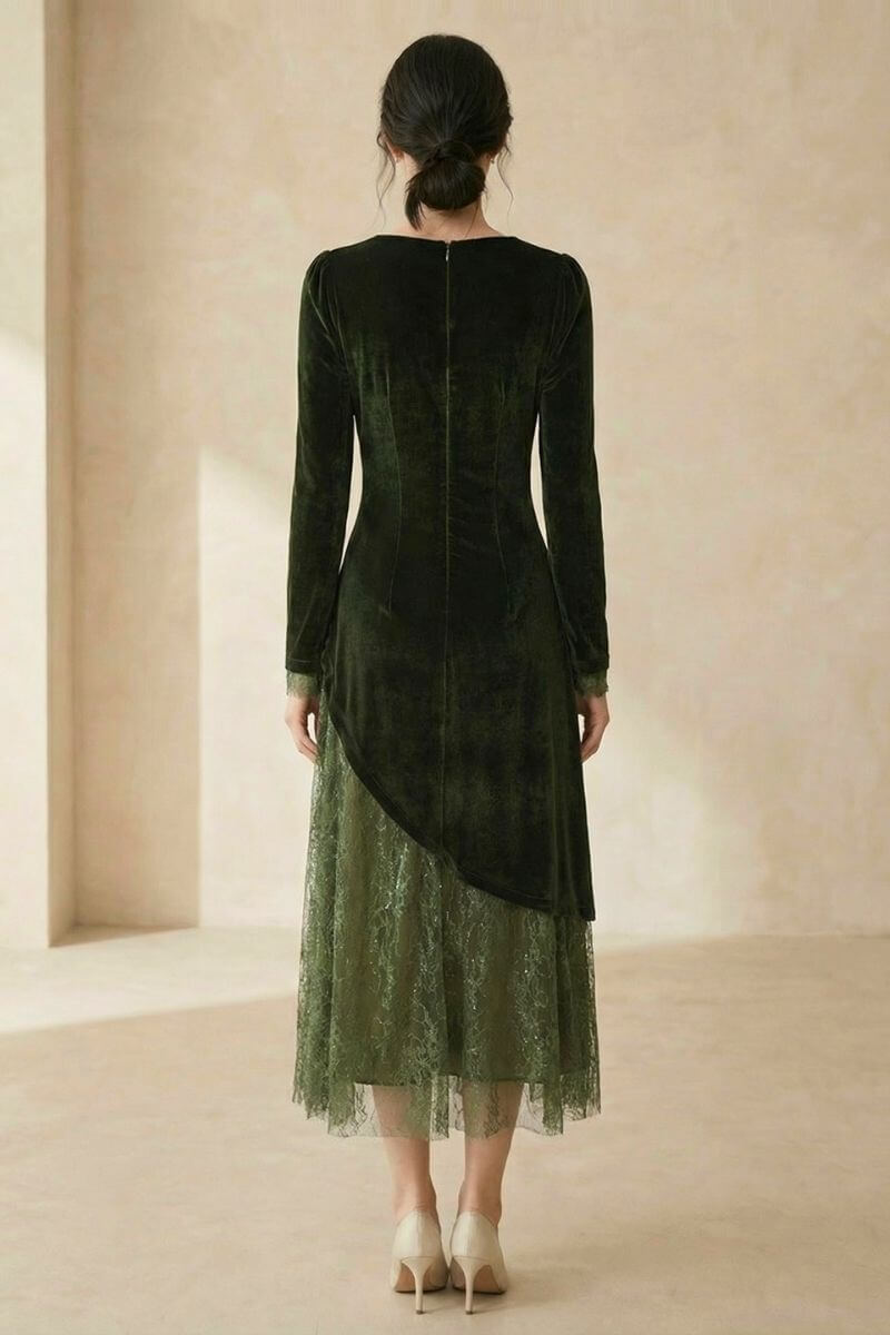 A woman shown from the back wearing a dark green velvet midi dress with an asymmetrical lace overlay hem, standing in a neutral indoor space.