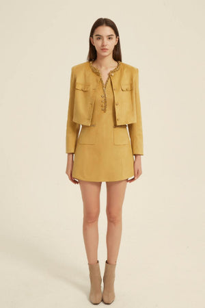 Front view of a mustard yellow two-piece set including a sleeveless mini dress and cropped jacket with crystal-beaded neckline and gold buttons — chic and feminine design.