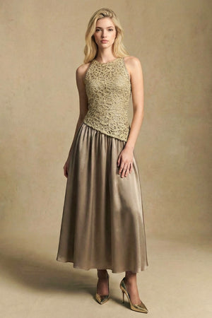 Model wearing a gold lace halter-neck midi dress with an asymmetric fitted bodice and softly flowing skirt, styled with pointed heels against a warm studio backdrop.