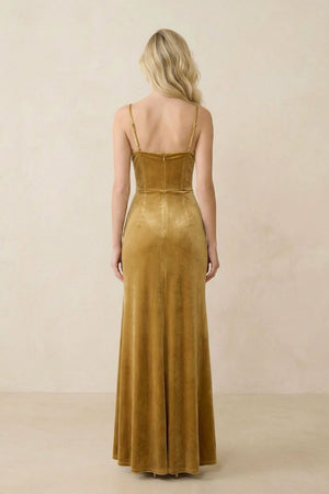 Back view of a gold velvet maxi dress highlighting the clean straight back neckline, adjustable straps, and smooth velvet drape through the skirt.