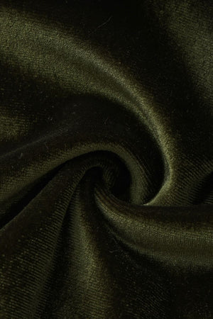 A close-up detail image of deep green velvet fabric showing its soft, plush texture and luxurious sheen in a twisted fold.