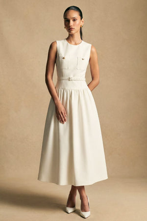 Model posing at a slight angle in an ivory embroidered halter maxi dress, highlighting the floral texture and softly contoured waistline.
