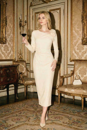 Woman in an ivory floral-shoulder midi dress holding a wine glass inside an ornate gold-trimmed interior.