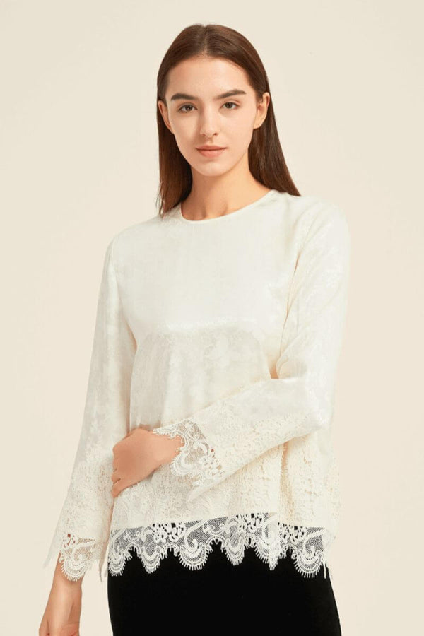 Front view of an ivory long-sleeve lace blouse with jacquard satin texture and intricate lace detailing at hem and cuffs — timeless minimal style from Sioéne.