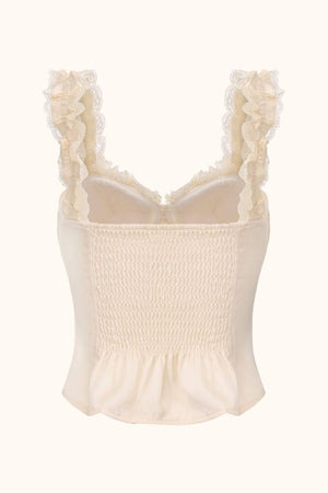 A back view of an ivory corset-style top with smocked elastic panels, ruffled lace shoulder straps, and a softly flared hem.