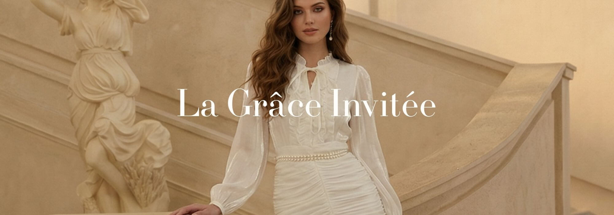 A woman stands on an elegant stone staircase wearing an ivory sheer long-sleeve blouse and layered midi skirt with soft ruffles, styled with a pearl waist detail in a classic European interior, evoking refined evening elegance in Sioéne’s La Grâce Invitée collection.