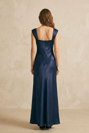 Back view of a navy satin maxi dress showing wide shoulder straps, a clean straight back neckline, and a fluid full-length skirt.