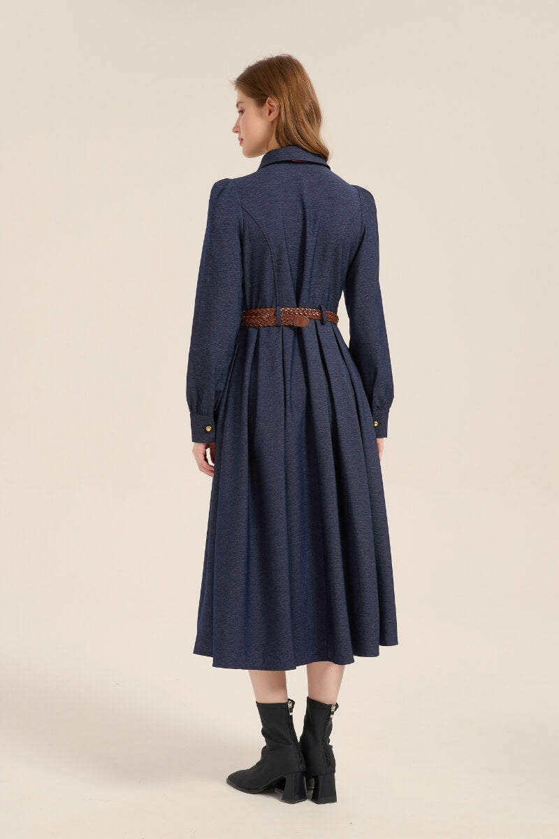 Back view of a navy twill midi dress showing tailored seams, pleated skirt, and brown braided belt, styled with black ankle boots.