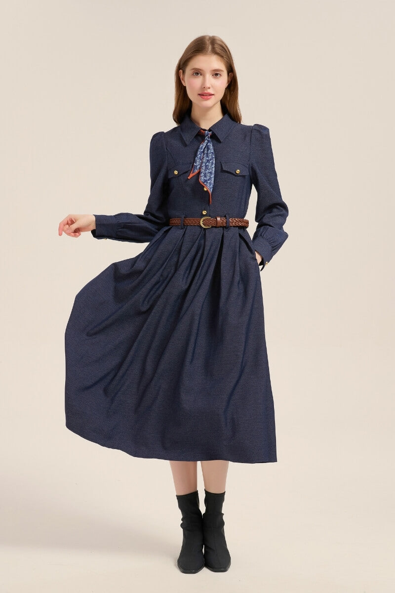 Model wearing a navy twill belted dress with long sleeves, structured collar, and pleated skirt for a polished everyday look.