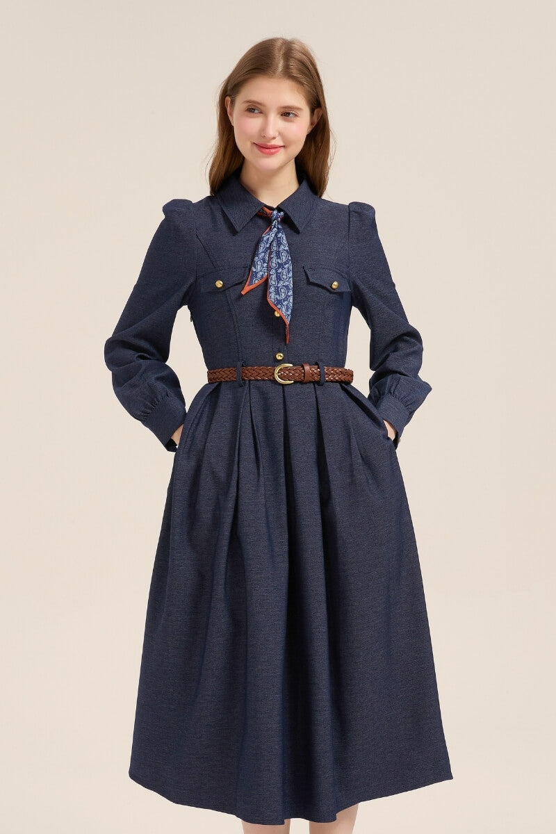 Front view of a navy twill midi dress featuring puff shoulders, long sleeves, gold button placket, and a classic brown woven belt.