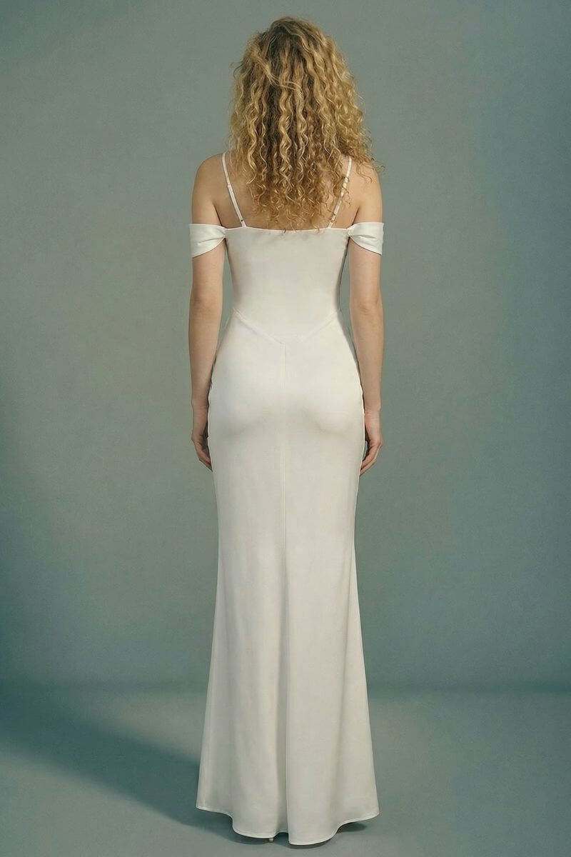 Back view of an ivory off-shoulder maxi dress with slim shoulder straps, clean corset back lines, and a smooth satin skirt falling to the floor.