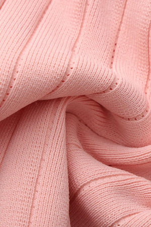 Close-up of soft pink ribbed knit fabric showing detailed texture, stretchy material, and fine sweater knit pattern.