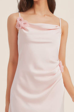 Detailed view of the pink satin dress showing the smooth silky texture and handcrafted floral embellishments with beaded centers.