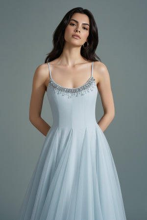 Close-up of the powder blue tulle maxi dress highlighting the fine beaded trim along the scoop neckline and softly structured bodice.
