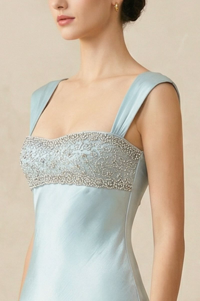 Close-up of the powder blue satin maxi dress highlighting the intricate beaded straight neckline and smooth satin texture across the bodice.
