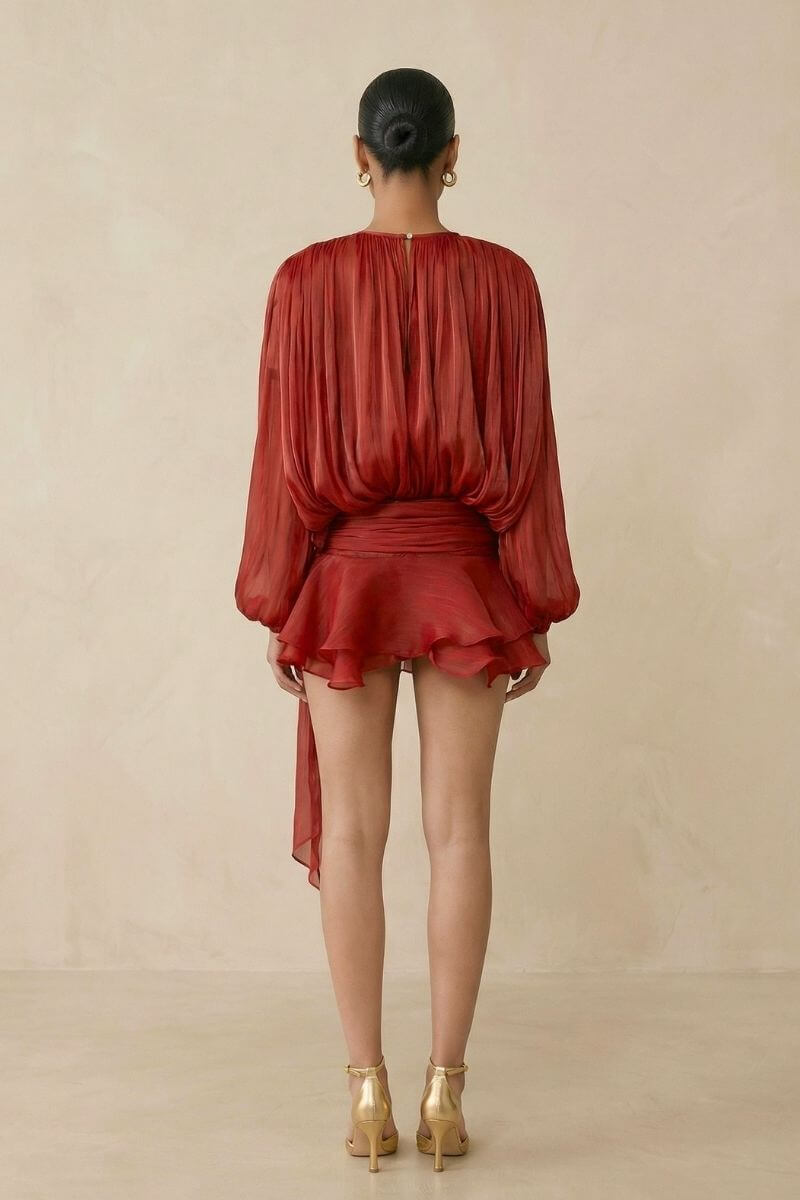 Back view of the red chiffon long-sleeve mini dress showing the softly gathered back neckline, relaxed blouson shape, and airy layered hemline.