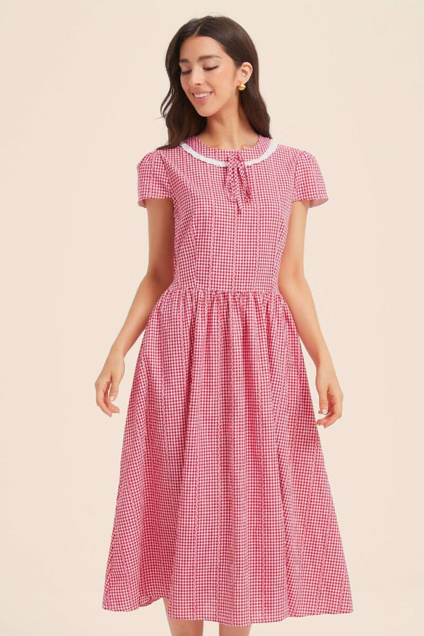 Front bodice detail of a red gingham dress highlighting the lace-trim collar, tie-neck, princess seams, and gathered waist.