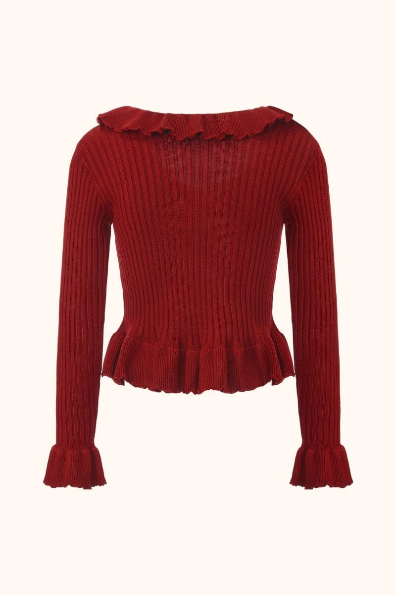 Back view of a red ribbed knit sweater with a subtle ruffle neckline, long sleeves, and a fitted ribbed texture throughout.