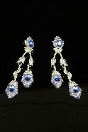 Articulated drop earrings showcasing multiple sapphire-blue stones set in a vintage-inspired silver-tone frame, designed to sway softly with each movement.