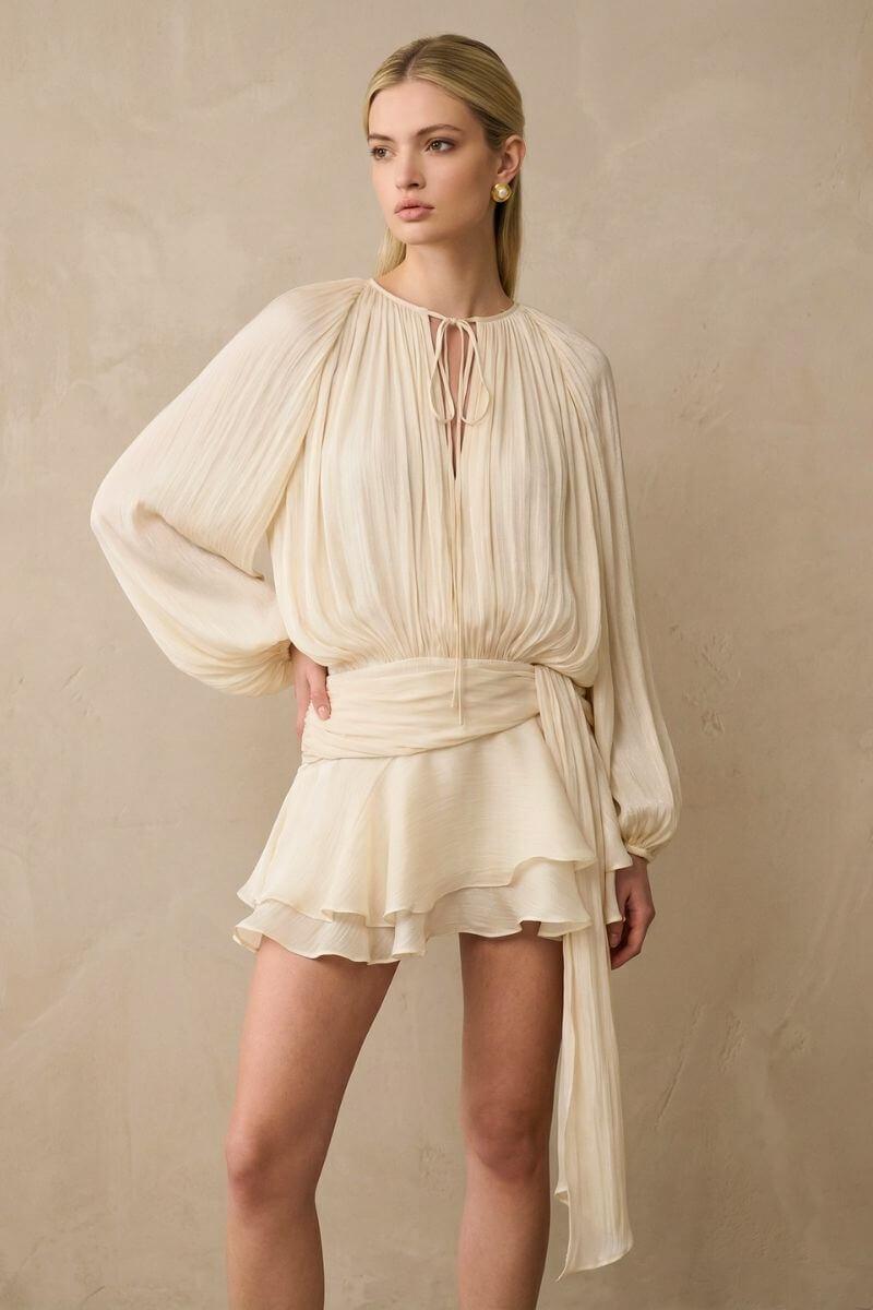 A close view of the soft pearl pleated chiffon mini dress set showing the delicate pleats, tie-neckline, cinched waist, and layered skirt texture.