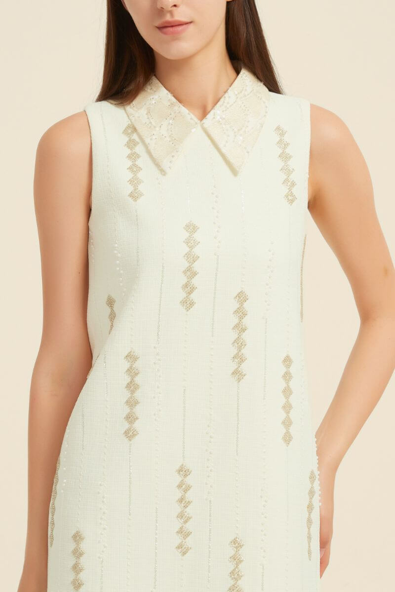 Ivory mini dress featuring lace collar, beaded gold embroidery, and structured sleeveless silhouette.