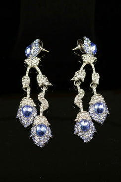 Statement earrings with layered blue oval crystals and sparkling clear rhinestones, connected by delicate articulated links for elegant movement.