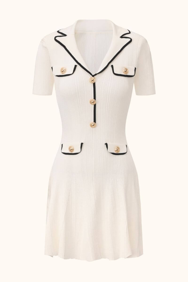 A white short-sleeve knit mini dress with black contrast trim, gold buttons, and a fitted silhouette displayed on a neutral background.
