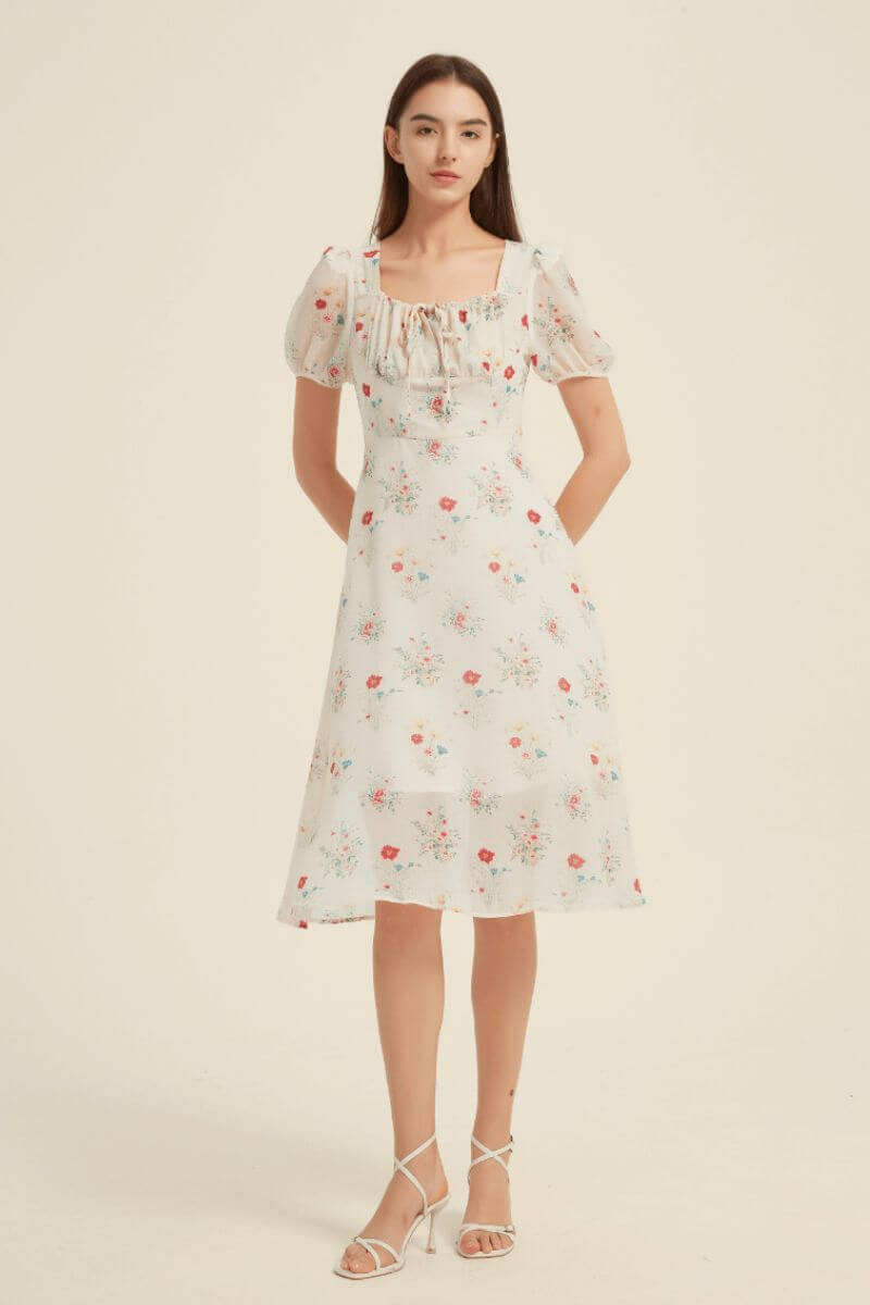 Front view of a white floral midi dress with puff sleeves, ruched square neckline, and feminine silhouette — romantic garden dress from Sioéne.