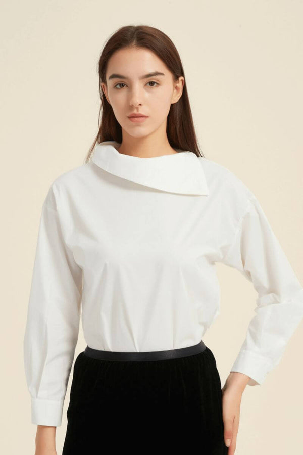 Front view of a white asymmetric-collar blouse styled with a black waistband velvet-finish skirt — refined and contemporary outfit by Sioéne.