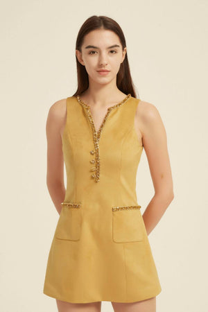 Front view of a sleeveless yellow mini dress featuring beaded trim around the neckline and pockets, accented with jeweled buttons — chic and feminine design.