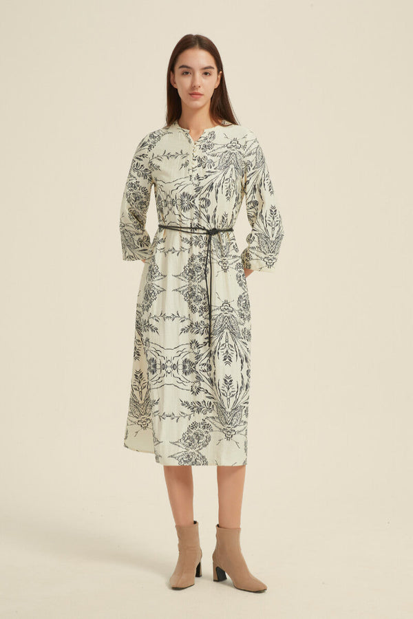 Angled front view of a cream midi dress with a detailed black botanical print, loose three-quarter sleeves, and a belted waistline.