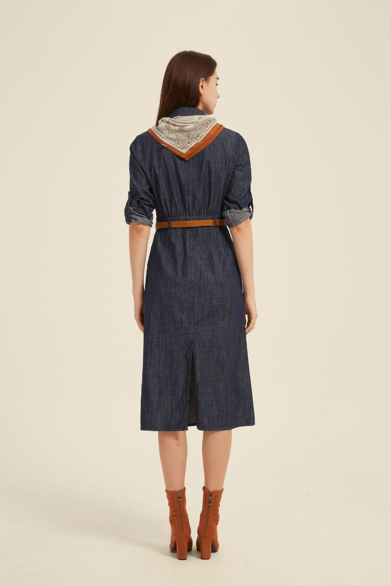 Back view of a denim midi shirt dress with a brown belt, rolled sleeves, center back vent, and a printed scarf draped over the shoulders.