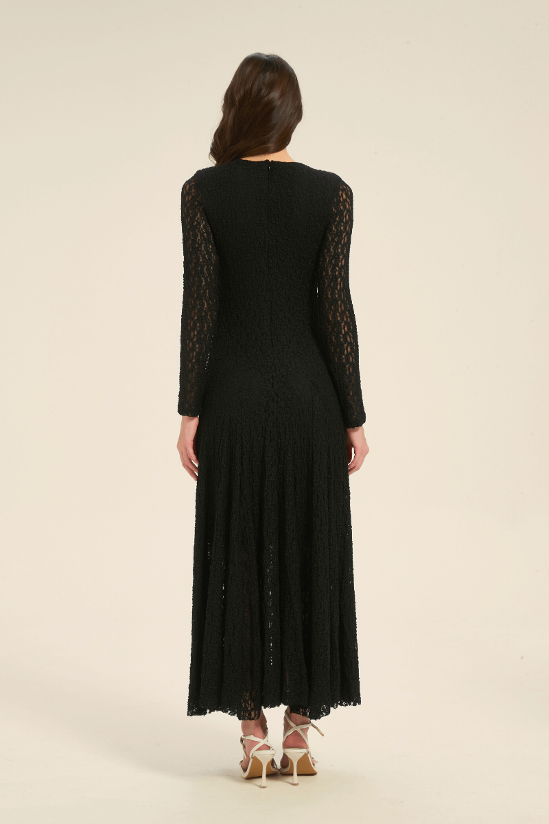Back view of black lace long sleeve maxi dress with flowing hem and delicate lace texture.