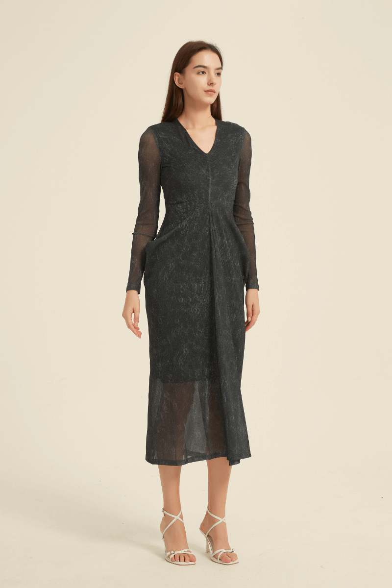 Model wearing a black sheer long sleeve midi dress with V-neckline and flowy silhouette, perfect for evening elegance and formal occasions.