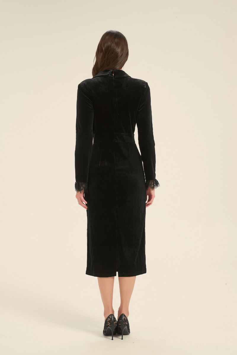 Back view of black velvet midi dress with tailored waist and subtle slit, finished with long sleeves.