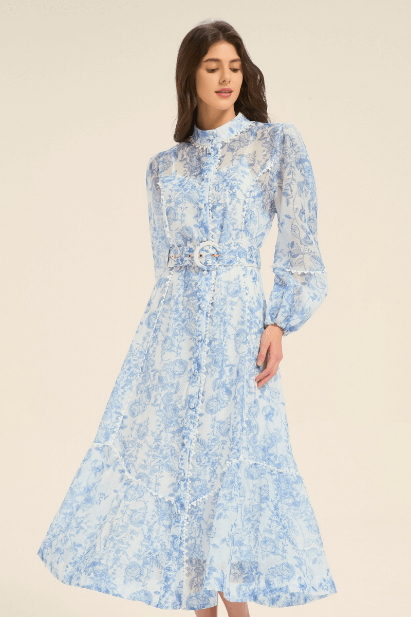 Close-up of a blue floral print midi dress with puff sleeves, belted waist, and button details.