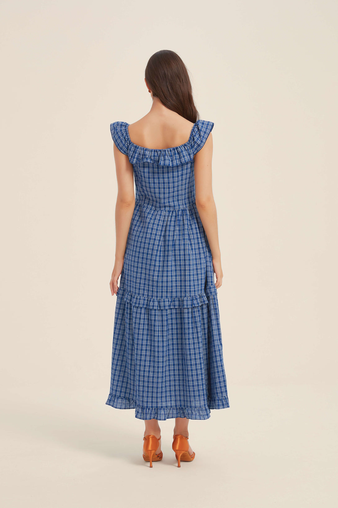 Back view of a blue gingham ruffled maxi dress with cap sleeves and smocked detailing — feminine and flattering from every angle.