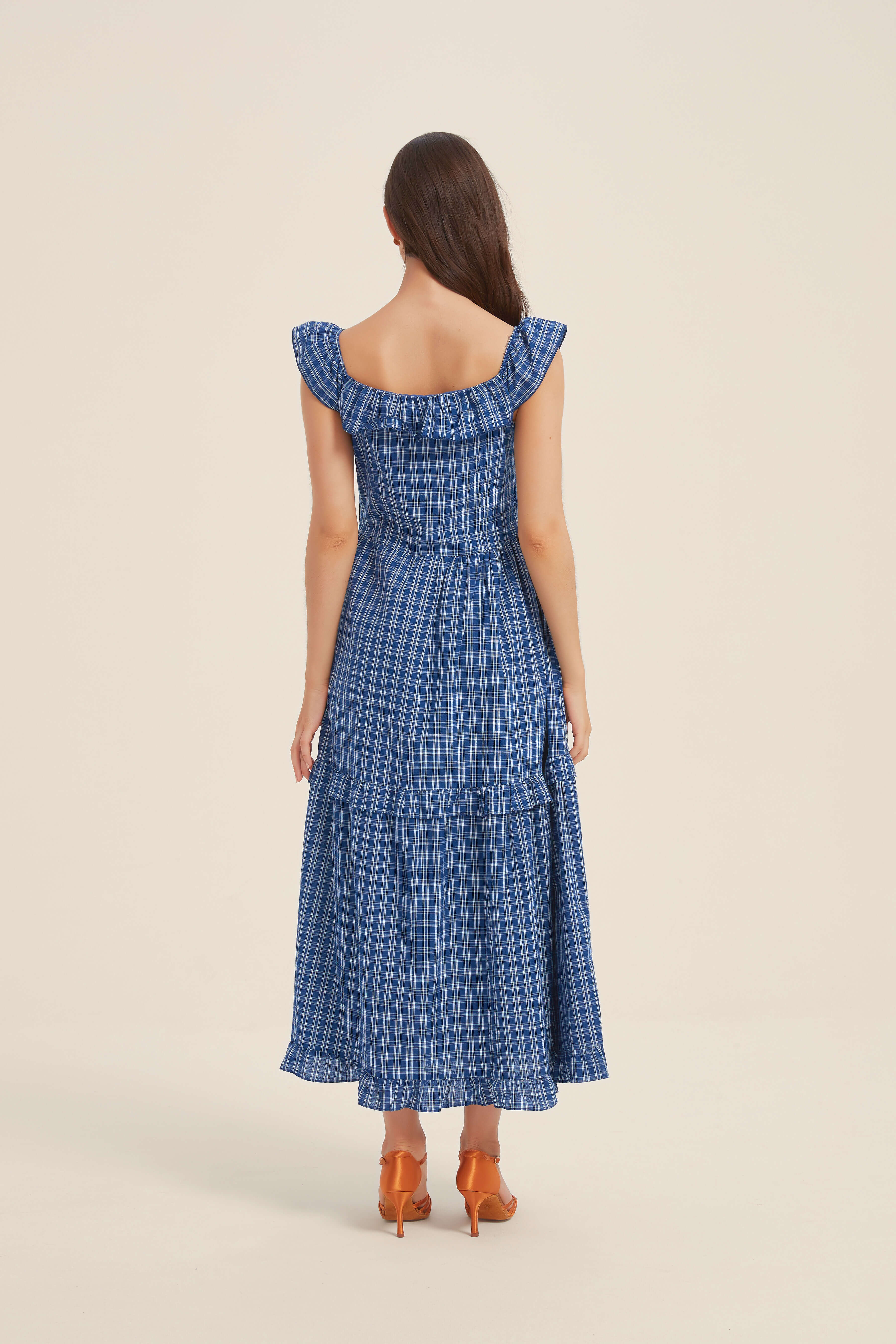 Back view of a blue gingham ruffled maxi dress with cap sleeves and smocked detailing — feminine and flattering from every angle.