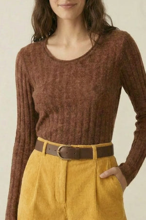 Close-up of a brown ribbed knit sweater tucked into yellow corduroy shorts with a brown belt, highlighting the cozy knit texture.