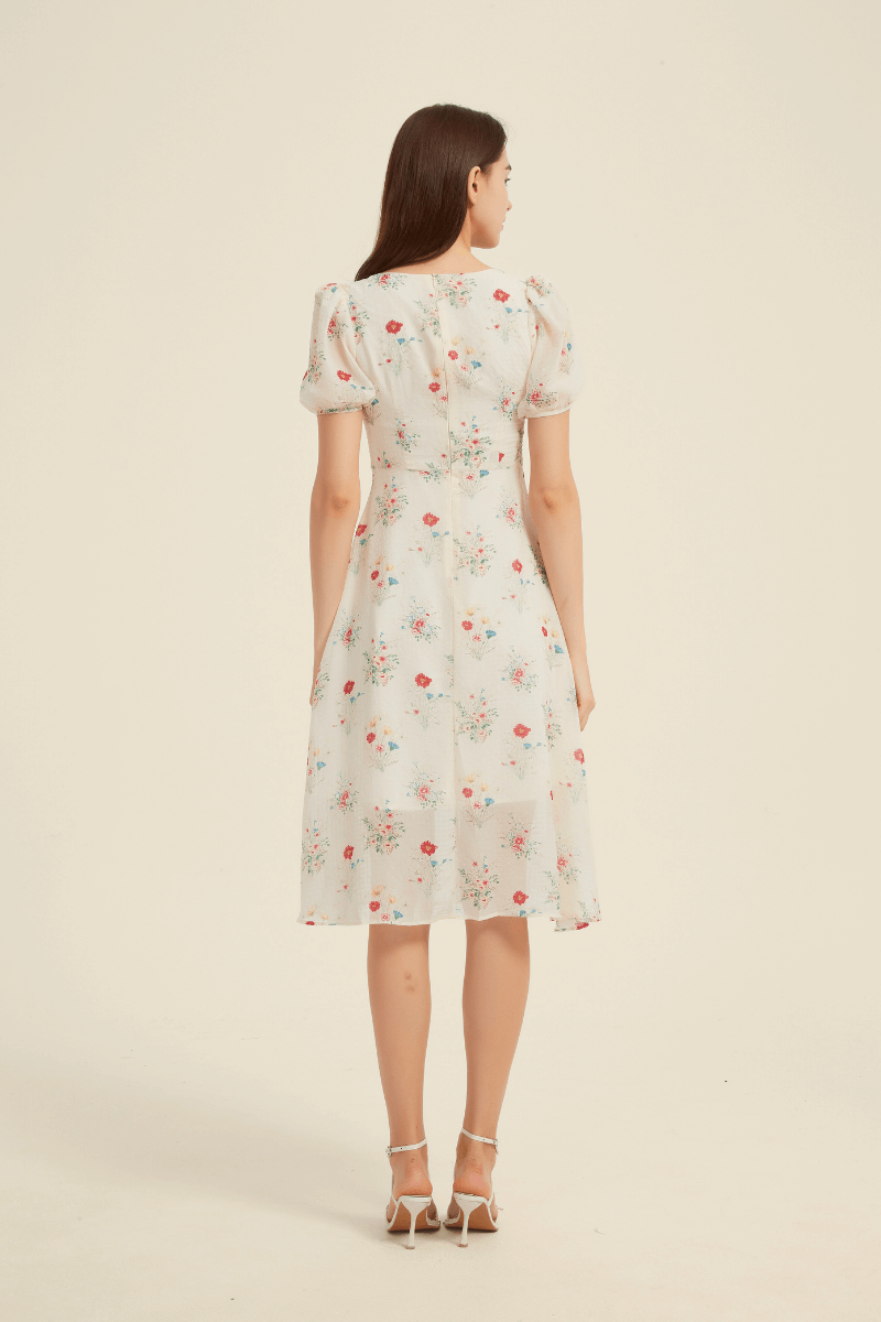 Back view of a cream floral midi dress featuring a square neckline, puff sleeves, fitted waist, and flowy A-line skirt.