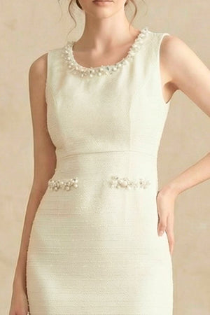 Close-up of the ivory tweed midi dress showing pearl embellishments along the neckline and waist seams.