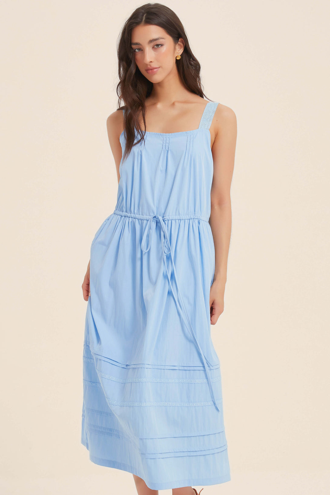 Front close-up of light blue sleeveless midi dress with square neckline, wide straps, pintuck skirt detail, and adjustable drawstring waist.