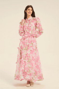 Front view of pink floral maxi dress featuring puff sleeves, pearl button details, and a matching fabric belt.