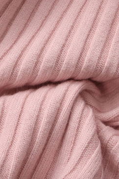 Close-up of a soft pink ribbed knit sweater fabric showing its cozy texture and fine stitching, highlighting the material used for Sioéne’s ruffled pink knit top.