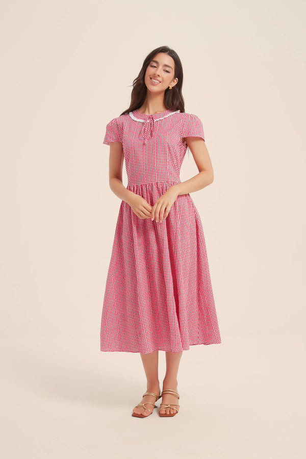 Front view of red gingham midi dress with puff sleeves, white lace collar, and gathered waist