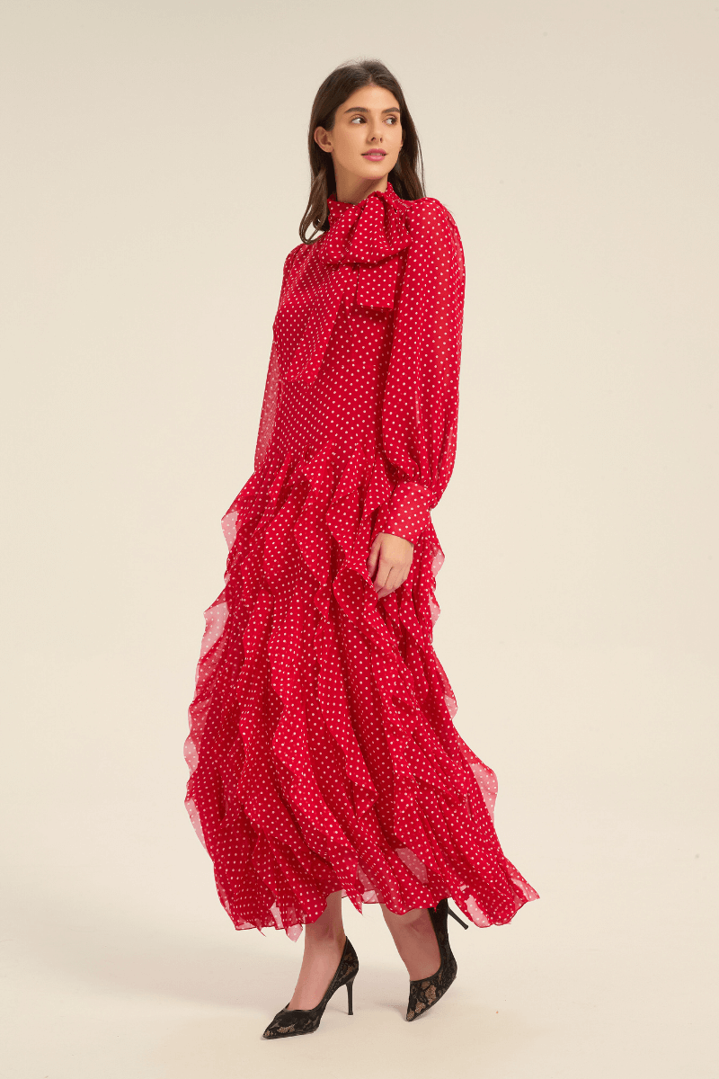 Side view of red polka dot midi dress with cascading ruffles and bow tie collar.