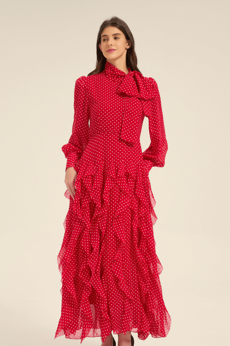 Front view of red polka dot tiered ruffle midi dress with long sleeves and bow tie neckline.
