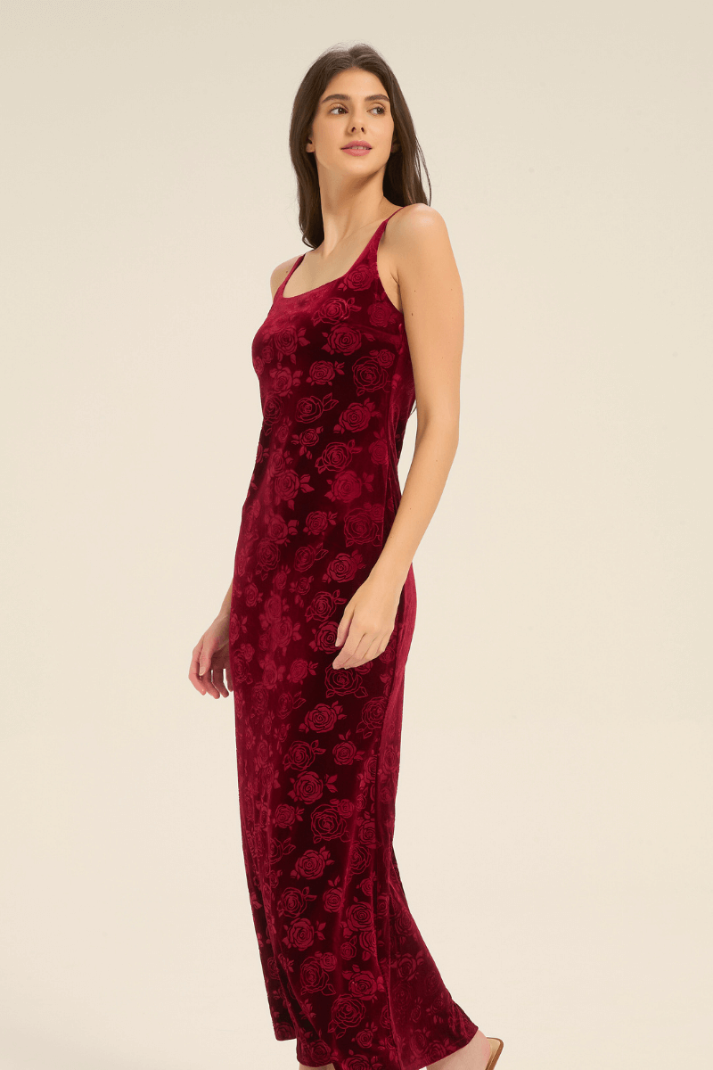 Angled side view of red velvet rose-pattern slip dress showing elegant silhouette.