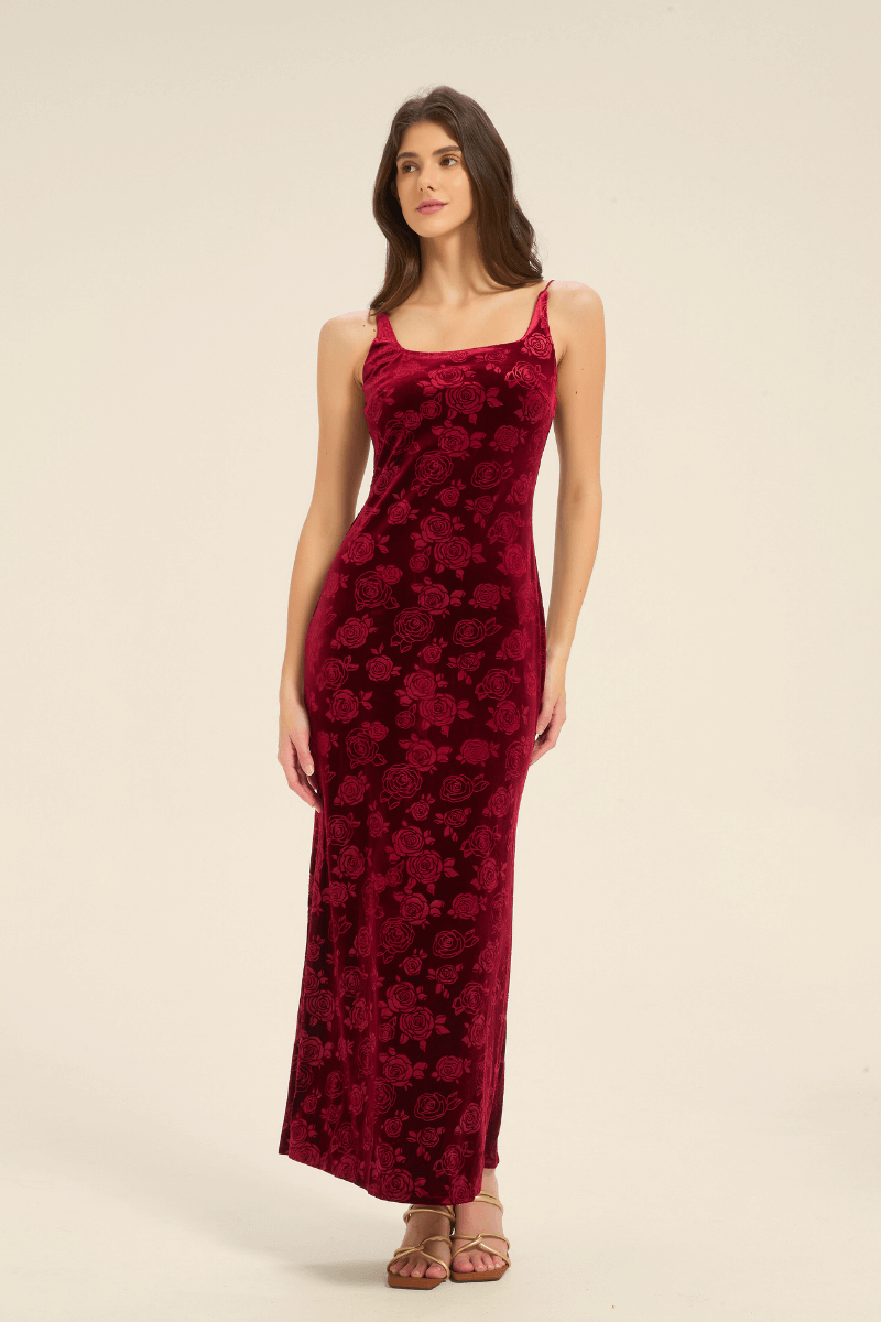 Model wearing a sleeveless red velvet slip dress with rose pattern, front full-length view.